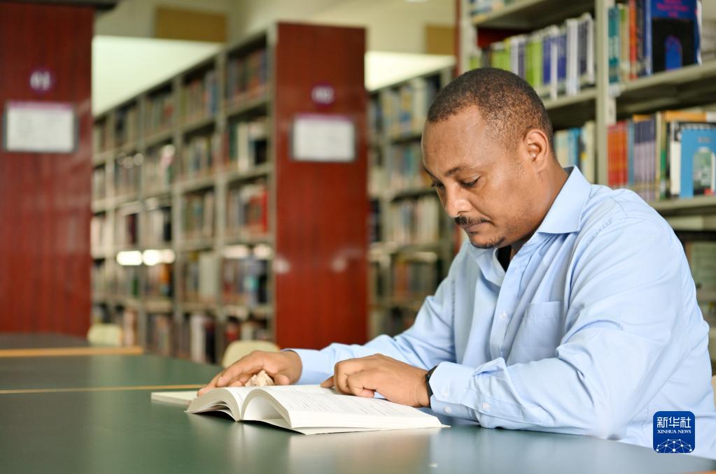 在天津職業技術師范大學圖書館,韓士蘭翻閱外文書籍(8月12日攝)。新華社記者 李然 攝