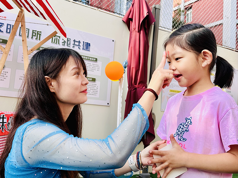 9月1日,北京市朝阳区劲松第一幼儿园举办了主题为“太阳花的世界——向阳花开,初秋相见”的开学典礼。老师们设计制作了欢迎小朋友的展板、漂亮的气球拱门,让孩子们走过“快乐门”“健康门”“成长门”,希望孩子们在新学期能够快乐健康成长。图为老师在小朋友的额头点朱砂。北京市朝阳区教委供图