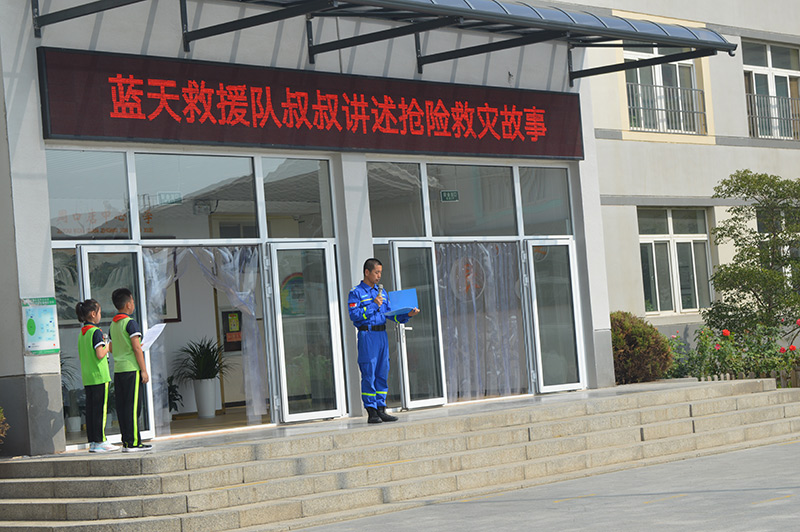 9月1日,北京市房山区周口店中心小学的开学典礼既庄严又热烈。学校请来了来蓝天救援队队员,为同学们宣讲在洪水灾害中抢险的“故事”,让同学们为自己是中国人而感到骄傲。图为蓝天救援队队员为学生们上“开学第一课”。北京市教委供图